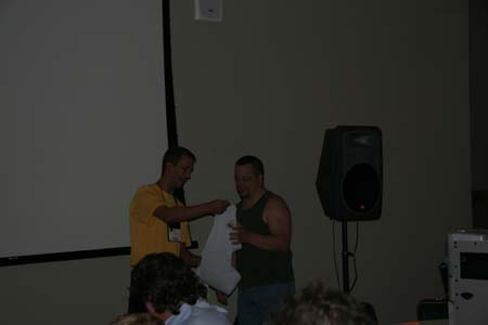 Jeff Rhodes giving Denny Dedmore a "Help Desk Staff" T-shirt for helping other attendees.